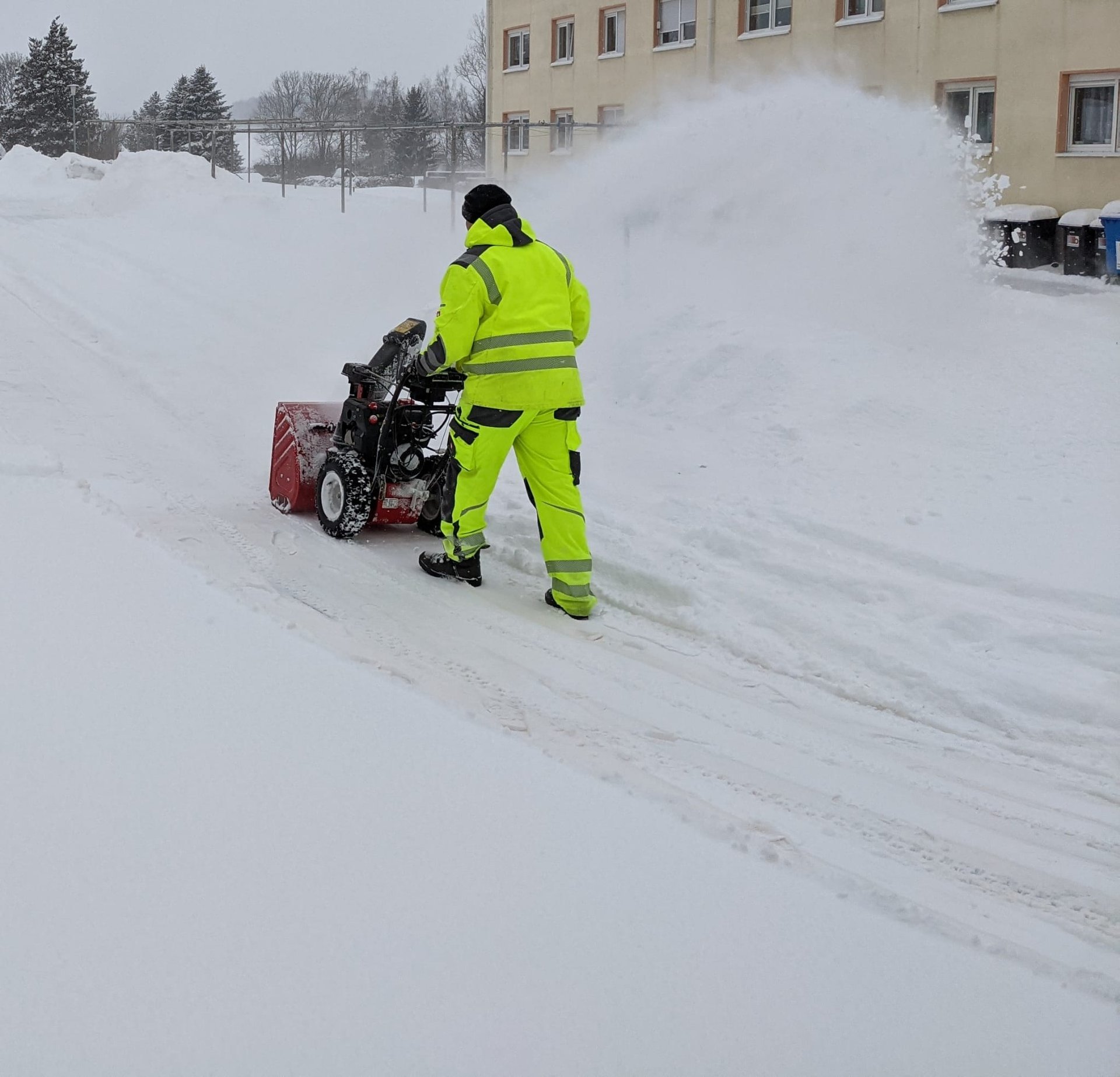 Mitarbeiter von LFH der Dienstleister räumt mit der Schneefräse einen verschneiten Weg
